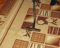 The head of a modern vacuum cleaner against the background of a carpet. Close. photo