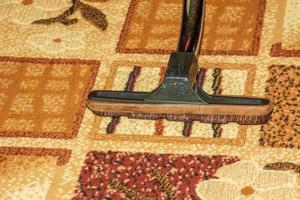 The head of a modern vacuum cleaner against the background of a carpet. Close. photo