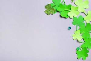 St. Patrick's Day minimalistic background. Paper clover leaves on grey background with copy space photo