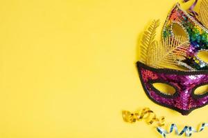 Festive face masks for masquerade or carnival celebration on colored background. Blank greeting card or invitation photo