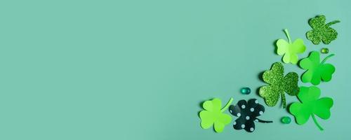 St. Patrick's Day banner. Paper clover leaves on colored background with copy space photo