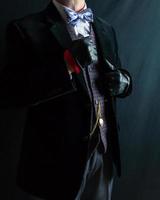 retrato de Caballero en oscuro traje y cuero guantes en pie generosamente Clásico estilo y retro moda. agudo vestido hombre para formal evento. foto