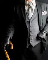 Portrait of Gentleman in Dark Suit Holding Umbrella on Black Background. Vintage Style and Retro Fashion. photo