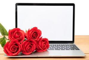 Red rose and laptop mockup on white photo