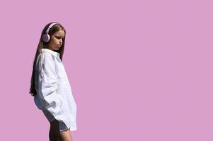 A girl in a white shirt, standing on a pink background. Design for the banner. photo