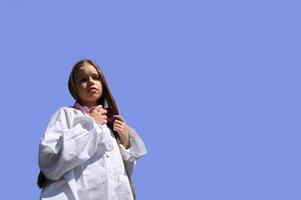 A girl in a white shirt, standing on a pink background. Design for the banner. photo