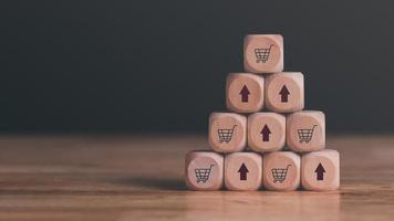 wooden blocks stacked on the table, shopping carts and arrows representing sales or business growth, Online shopping concept, e-commerce, online store ,SME, Startup or small business entrepreneur photo