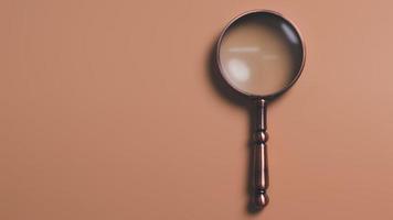 A magnifying glass is placed on an orange background, information search concept, conducting research, acquiring knowledge from study and research, Search Engine Optimization. photo