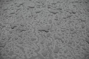 gotas de lluvia en superficie. detalles de lluvia. mojado vaso. foto
