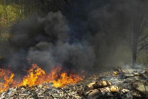 Fire in landfill. Fire and smoke. Burning garbage. photo