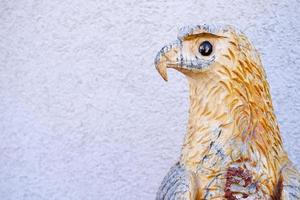Vintage Wooden Eagle Doll in the Park with Stucco Wall Background. photo