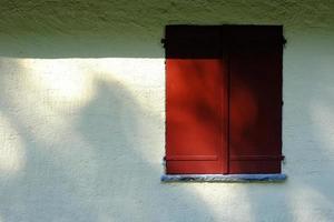Red Wooden Window on White Stucco Wall Background. photo