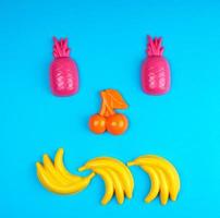 multicolored plastic toys fruits on a blue background photo