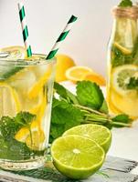 refreshing drink lemonade with lemons, mint leaves, lime in a glass photo