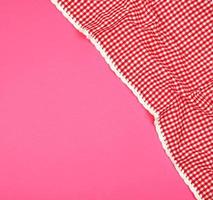 white red checkered kitchen towel on a pink background photo