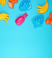 multicolored plastic toys fruits on a blue  background photo