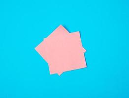 pink  empty paper square stickers on blue background photo