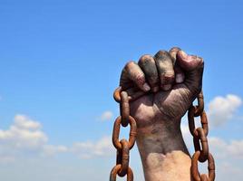 Rusty iron chain in human male right hand photo