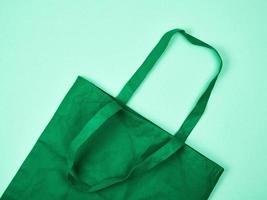 empty green ecological bag made of viscose with long handles photo