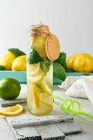 suave bebida limonada en un vaso botella y maduro Fresco limones foto