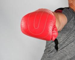 adult athlete in gray uniform and red leather glove strikes forward photo