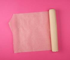 rolled brown parchment paper roll for baking on a white background photo