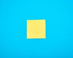 yellow empty paper square stickeron blue background photo