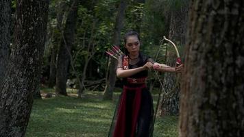 Close up shot of woman hand ready to shoot an arrow from a gold bow video