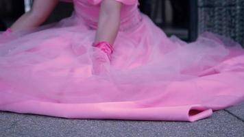 une princesse rose assise sur le sol tandis que sa robe recouvre le sol de beauté video