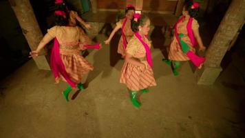 Balinese people dance together while the ritual ceremony begins in a yellow dress and green scarf inside the village video