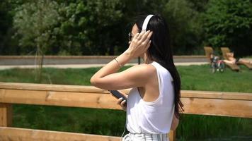 Happy young urban woman enjoy music outdoors video