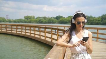 Happy young urban woman enjoy music outdoors video