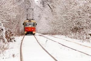 un viejo tranvía moviéndose a través de un bosque de invierno foto