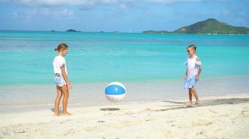 petites filles adorables jouant au ballon sur la plage video