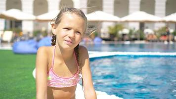 belle petite fille s'amusant près d'une piscine extérieure video