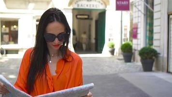 mujer joven con un mapa de la ciudad en la ciudad. chica turística de viaje con mapa en viena al aire libre durante las vacaciones en europa. video