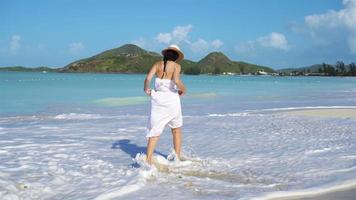 jovem mulher bonita na praia tropical de areia branca. video