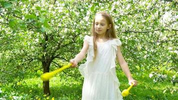 aanbiddelijk weinig meisje in bloeiend appel tuin Aan mooi voorjaar dag video