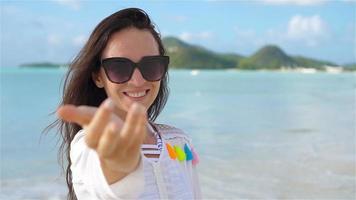 jovem mulher bonita se divertindo na praia tropical. video