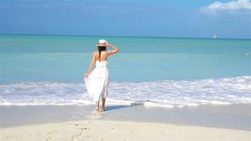 Young beautiful woman on white sand tropical beach. video