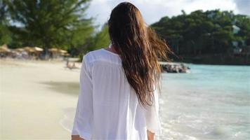 jovem mulher bonita na praia tropical de areia branca. video