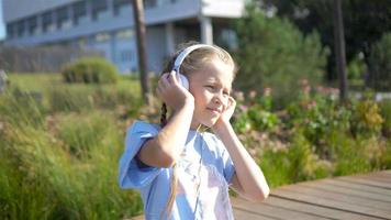 Little adorable girl listening music in the park video