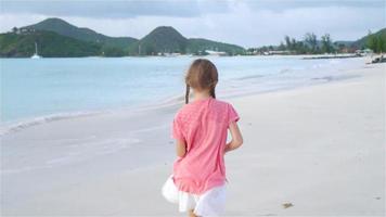 Sihouette of little girl walking on the beach at sunset. video