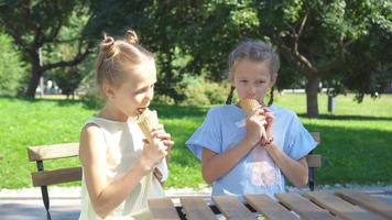 weinig meisjes aan het eten ijsje buitenshuis Bij zomer in buitenshuis cafe video