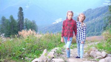 Beautiful happy little girls in mountains in the background of fog video