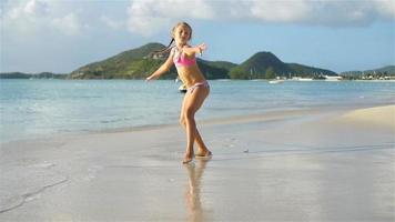 Little active girl making cartwheels on white beach. video