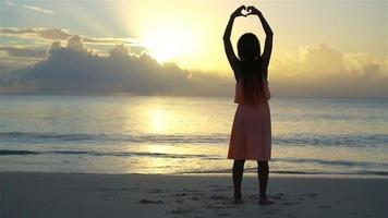 förtjusande Lycklig liten flicka på vit strand på solnedgång. video