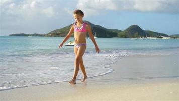adorável menina divirta-se na praia tropical video