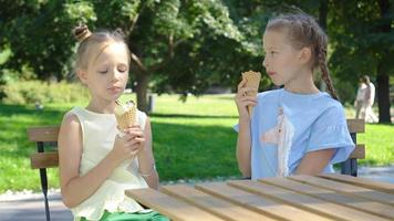 kleine Mädchen, die im Sommer im Café im Freien Eis essen video