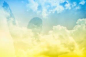 Double Exposure of Jesus Silhouette on Blue Sky and White Cloud Background, Suitable for Christian Religion Concept. photo